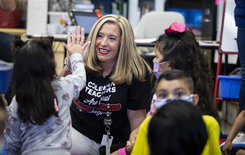 Principal Kelly Marotz gives a child a high five 